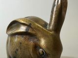 un petit lapin en bronze posé sur une table