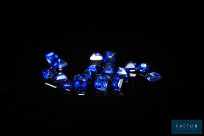 un gros plan sur un ensemble de saphirs bleus posés sur une surface noire