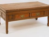 a small wooden table with two drawers on it