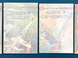 quatre livres sont alignés sur une surface bleue
