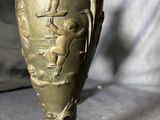 a bronze vase with a bird on top of it