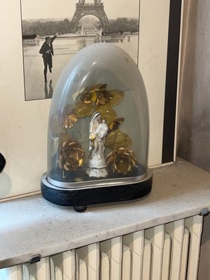 a glass clochet with gold leaves in it sitting on a radiator