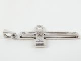 a small silver cross with a diamond on it