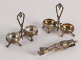 three silver plated dishes and spoons on a white surface