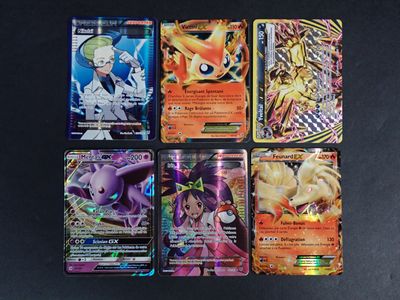 six cartes Pokémon différentes posées sur une table noire