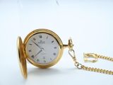 a gold pocket watch with roman numerals on it