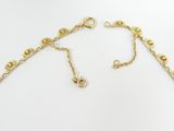 a close up of a gold necklace on a white background