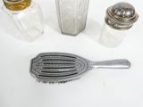 three salt and pepper shakers and a brush on the table