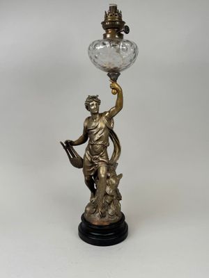 une lampe ancienne en laiton surmontée d'un abat-jour en verre