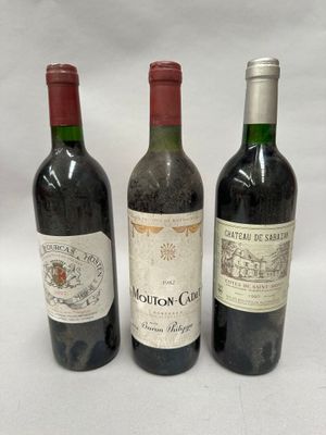 three bottles of wine are lined up on a white surface