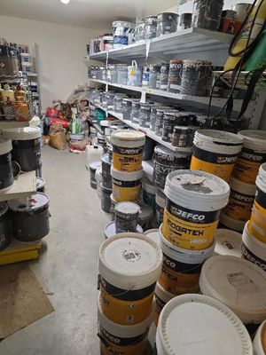 de nombreux seaux de peinture sur les étagères du magasin