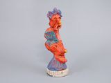 statue of a man sitting on top of a red and blue statue