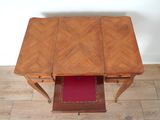 a small table with a drawer underneath it on the floor