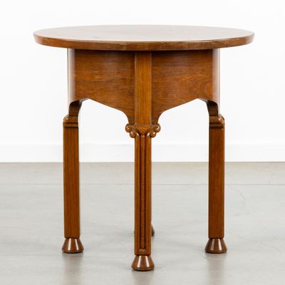 une petite table ronde avec un plateau et des pieds en bois