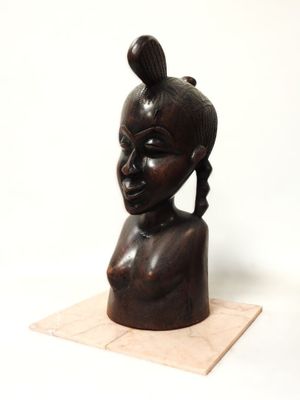 une image représentant une sculpture en bois représentant une tête de femme posée sur un socle en marbre