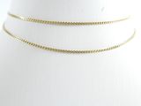 un gros plan sur un collier ras-du-cou en or porté par un mannequin