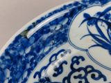 a blue and white plate with a flower design on it