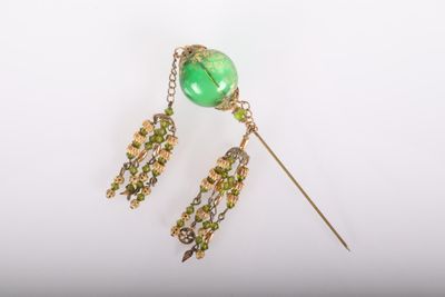 gros plan sur une paire de boucles d'oreilles avec des perles vertes