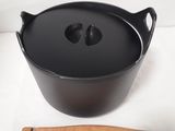 a black pot with a wooden spoon next to it