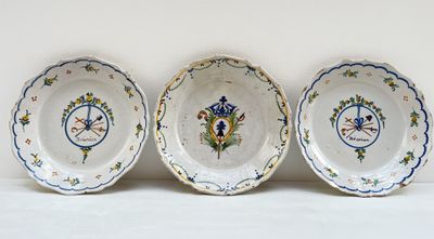 trois assiettes avec des motifs sont posées sur une surface blanche
