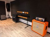 a room with a guitar, amplifier, and speakers in it