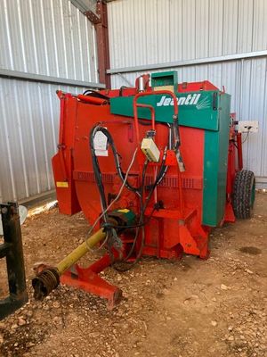 une machine rouge et verte qui est garée dans la poussière