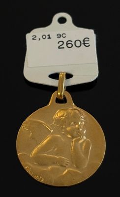 un gros plan d'une médaille d'or à laquelle est attachée une étiquette