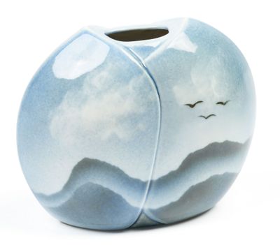 a blue vase with birds flying in the sky