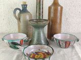 many different types of vases and bowls sitting on a table