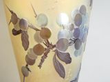 un vase en verre orné d'un motif de feuilles et de fleurs