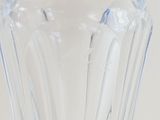 a clear glass vase with a blue handle on a table