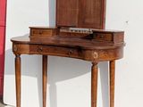 a small wooden vanity with a mirror on top of it