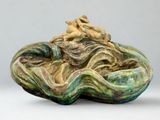 une sculpture en céramique représentant un homme et une femme sur une coquille de palourde