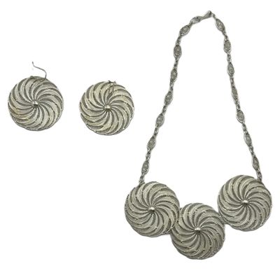 a close up of a necklace and earrings on a white background