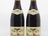 two bottles of wine sitting next to each other on a white surface