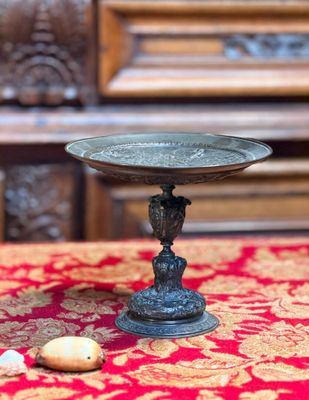 un petit bol en métal posé sur une nappe rouge