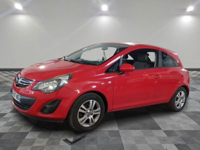 a red car is parked in a room with a checkered floor