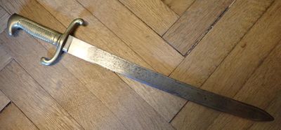 une épée qui est posée par terre, sur le sol
