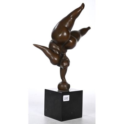 une statue en bronze représentant un homme faisant le poirier sur un socle