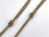 a pair of long gold chain necklaces on a white surface