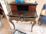 un petit bureau sur lequel est posée une lampe, dans une pièce
