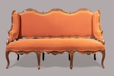 an orange couch that is sitting on a gray surface