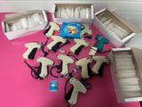 de nombreux modèles différents de pistolets à colle posés sur une table rose