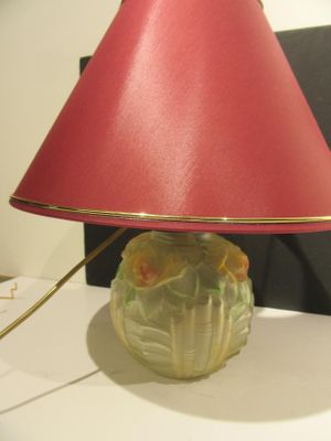 a lamp that is sitting on a table with a red shade on it