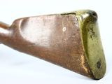 an old brass pipe with a wooden handle on a white surface