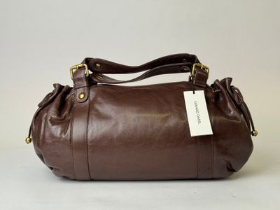 a brown leather handbag with a tag on it