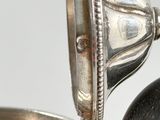 a silver tea pot with a handle on a table