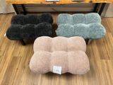 plusieurs coussins de différentes couleurs posés sur un parquet, devant une table