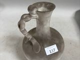 un petit vase muni d'une étiquette, posé sur une table