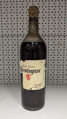 une vieille bouteille de vin posée sur un plan de travail blanc
